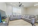 Spacious living room featuring an oversized gray couch and a ceiling fan at 4530 W Paradise Dr, Glendale, AZ 85304