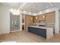 Spacious kitchen featuring modern appliances, stylish lighting, and a unique wine storage display at 6202 E Larkspur Dr, Scottsdale, AZ 85254