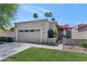 Lovely home with a two-car garage, desert landscaping, and a vibrant green lawn on a bright day at 7917 E Cactus Wren Rd, Scottsdale, AZ 85250