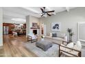 Bright living room featuring wood floors, a fireplace, a ceiling fan, and stylish, modern furnishings at 7917 E Cactus Wren Rd, Scottsdale, AZ 85250