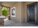 Inviting covered porch with decorative security screen door and neutral colored walls at 865 E Rojo Ct, Gilbert, AZ 85297