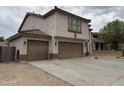 Tan two-story home featuring a tile roof and a three-car garage at 10528 W Jessie Ln, Peoria, AZ 85383