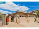 A well-kept two-car garage, desert landscaping, and tile roof under a bright blue and cloudy sky at 10652 W Coronado Rd, Avondale, AZ 85392