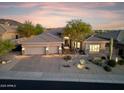 Luxury home with a three-car garage, desert landscaping, and a tile roof at 10811 E Acoma Dr, Scottsdale, AZ 85255