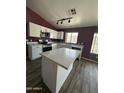 Modern kitchen with white cabinets, quartz countertops, and a large island at 12422 N 121St Dr, El Mirage, AZ 85335