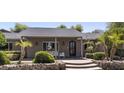 Inviting home entrance featuring a decorative glass door and manicured front yard with palm trees at 14749 E Pecos Rd, Gilbert, AZ 85295