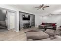 Spacious living room featuring a large sectional sofa, ceiling fans, and modern decor at 18484 W Westfall Way, Surprise, AZ 85374