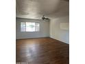Spacious living room featuring wood floors, a large window with great natural light, and a ceiling fan at 1907 W Gardenia Dr, Phoenix, AZ 85021