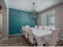 Bright dining room with paneled accent wall, chandelier, and a table set for eight at 19690 W Marshall Ave, Litchfield Park, AZ 85340