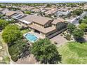 An aerial view displays a two-story home with a backyard pool and spa in a neighborhood with many other houses at 19943 E Strawberry Dr, Queen Creek, AZ 85142