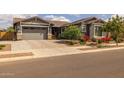 Attractive one-story home featuring a gray stucco exterior, a two-car garage, and a beautifully landscaped yard at 22670 E Russet Rd, Queen Creek, AZ 85142