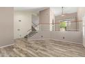 Bright, open-concept living area with wood-look floors, staircase, and plenty of natural light at 23829 N 59Th Dr, Glendale, AZ 85310