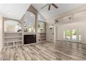 Open living room with high ceilings, built-in shelving, and a fireplace; bathed in natural light at 23829 N 59Th Dr, Glendale, AZ 85310