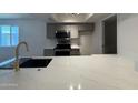 Bright kitchen featuring stainless appliances, stone countertops, and gray cabinets at 2625 W Ocotillo Rd # 4, Phoenix, AZ 85017