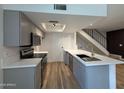 Well-lit kitchen with stainless appliances, a breakfast bar, and modern gray cabinets at 2625 W Ocotillo Rd # 4, Phoenix, AZ 85017