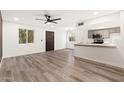 Bright and airy living area with wood-look floors, a view of the kitchen, and access to the front door at 2625 W Ocotillo Rd # 4, Phoenix, AZ 85017