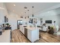 Modern kitchen featuring an island with pendant lights, stainless steel appliances, and wood floors at 2912 E Lucky Horseshoe Ln, San Tan Valley, AZ 85140