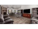 Spacious living room featuring wood flooring, a stone fireplace, and large windows at 3144 S Rogers --, Mesa, AZ 85202
