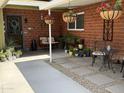 Charming brick patio featuring hanging flower baskets and a cozy seating area at 4008 W Citrus Way, Phoenix, AZ 85019