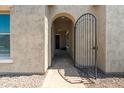Close-up of arched front entryway with security gate and stone walkway, creating curb appeal at 4671 N 185Th Ln, Goodyear, AZ 85395