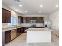 Bright kitchen boasts dark wood cabinets, granite countertops, stainless steel appliances, and a center island at 5041 S 252Nd Ave, Buckeye, AZ 85326