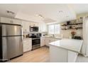 Modern kitchen with white cabinets, stainless steel appliances, and ample counter space at 6005 N Granite Reef Rd, Scottsdale, AZ 85250