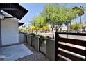 Cozy private patio with a fence and gate, offering a glimpse of the neighborhood street at 7531 E Billings St # 131, Mesa, AZ 85207