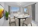 Bright dining room with modern chandelier, white table setting, and sliding door access to the outdoor patio at 8865 W Orange Dr, Glendale, AZ 85305