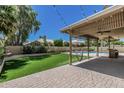 Beautiful backyard featuring a covered patio with a hammock, an inground pool, and manicured landscaping at 8911 E Sutton Dr, Scottsdale, AZ 85260