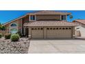 Charming two-story home featuring a clay tile roof, an attached two car garage, and desert landscaping at 8911 E Sutton Dr, Scottsdale, AZ 85260