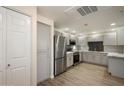 Full kitchen view with stainless steel refrigerator and appliances, modern countertops, and new laminate flooring at 9555 E Raintree Dr # 1055, Scottsdale, AZ 85260