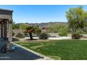 Backyard patio with a pool, lush green lawn, mountain views, and desert landscaping at 1532 W Glenhaven Dr, Phoenix, AZ 85045
