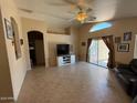 Bright living room featuring tile floors, ceiling fan, and sliding glass doors to the backyard at 1612 E Barbarita Ave, Gilbert, AZ 85234