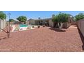 Backyard featuring a pool, lounge chairs, and lush landscaping, perfect for outdoor relaxation and entertainment at 1744 E Huber St, Mesa, AZ 85203