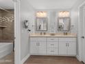 Bright bathroom features a double vanity, framed mirrors, and a separate shower and tub at 1744 E Huber St, Mesa, AZ 85203