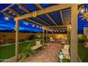 Landscaped backyard featuring a pergola, outdoor lighting, artificial grass, and desert plants at 18722 W Denton Ave, Litchfield Park, AZ 85340