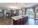 Open-concept kitchen with a large island, stainless steel appliances, and hardwood flooring at 18722 W Denton Ave, Litchfield Park, AZ 85340