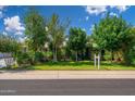 Charming single-story home with mature trees, lush landscaping, and well-maintained lawn at 2219 W Catalina Dr, Phoenix, AZ 85015