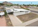 Single-story home with solar panels and a carport, offering modern efficiency and convenience at 2346 E Sylvia St, Phoenix, AZ 85022