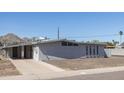 Front and side view of single-story home with gray stucco and a covered parking area on a sunny day at 2346 E Sylvia St, Phoenix, AZ 85022