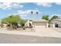 Charming home with desert landscaping, palm trees, and an arched entryway creates curb appeal at 7734 E Rose Ln, Scottsdale, AZ 85250