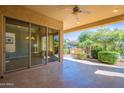 Inviting covered patio with tiled flooring, a ceiling fan, and views of the outdoor grill and landscaped yard at 791 E Vesper Trl, Queen Creek, AZ 85140