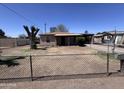Exterior front view of a single-story home featuring a chain-link fence and sparse landscaping at 112 S 28Th Dr, Phoenix, AZ 85009