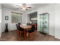 Dining room features hardwood floors, black modern chairs, large window, and modern display case at 14921 W Luna S Dr, Litchfield Park, AZ 85340