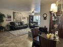 Comfortable living room featuring a plush leather sofa, ceiling fan, and decorative wall art at 17823 N 99Th Dr, Sun City, AZ 85373
