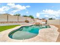 Sparkling pool featuring a rock waterfall feature in a private backyard oasis at 18286 La Posada Ct, Gold Canyon, AZ 85118