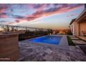 Backyard oasis featuring a sparkling pool, outdoor kitchen, and desert views at 20210 N Wagner Wash Dr, Buckeye, AZ 85396
