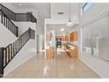 Bright open-concept living room with sleek staircase, soaring ceilings, tile floors, and modern finishes at 2206 S 114Th Ln, Avondale, AZ 85323
