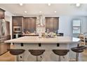 Modern kitchen island with counter seating, stylish backsplash, and stainless steel appliances at 2221 W Madisen Marie Ave, Queen Creek, AZ 85144