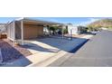 A mobile home is shown with covered parking and a fire hydrant, surrounded by desert landscaping at 2233 E Behrend Dr # 84, Phoenix, AZ 85024